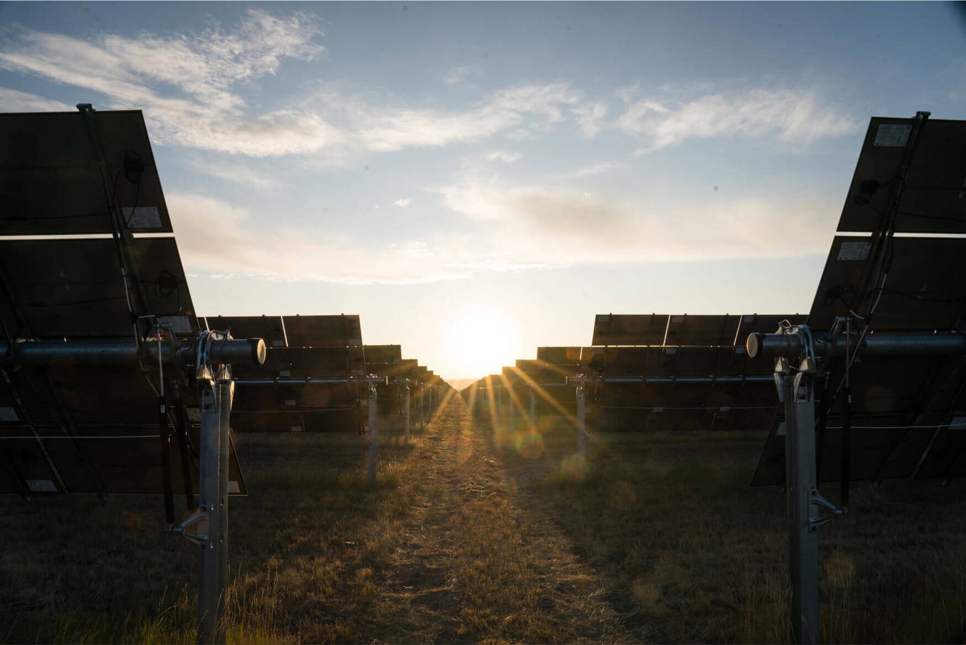 Sunrays shining between two rows of solar panels