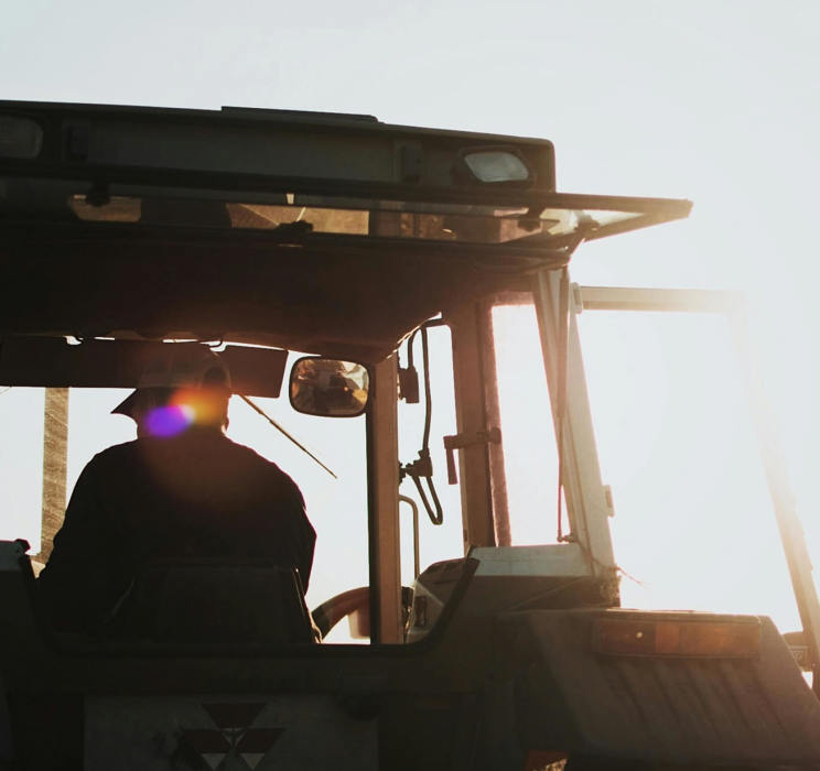 Silhouette of farmer on a tractor