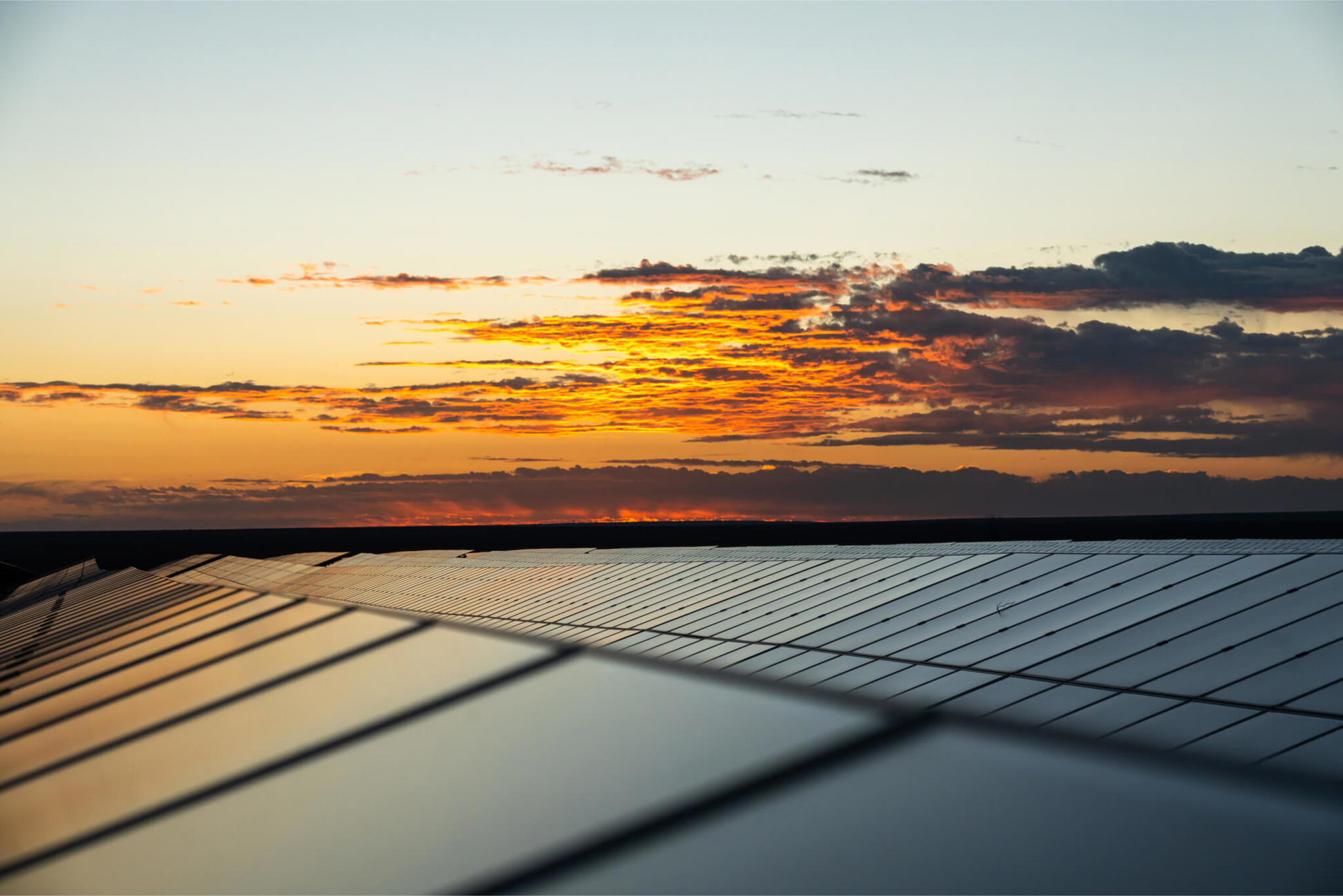 Solar panels reflecting a colourful sunset